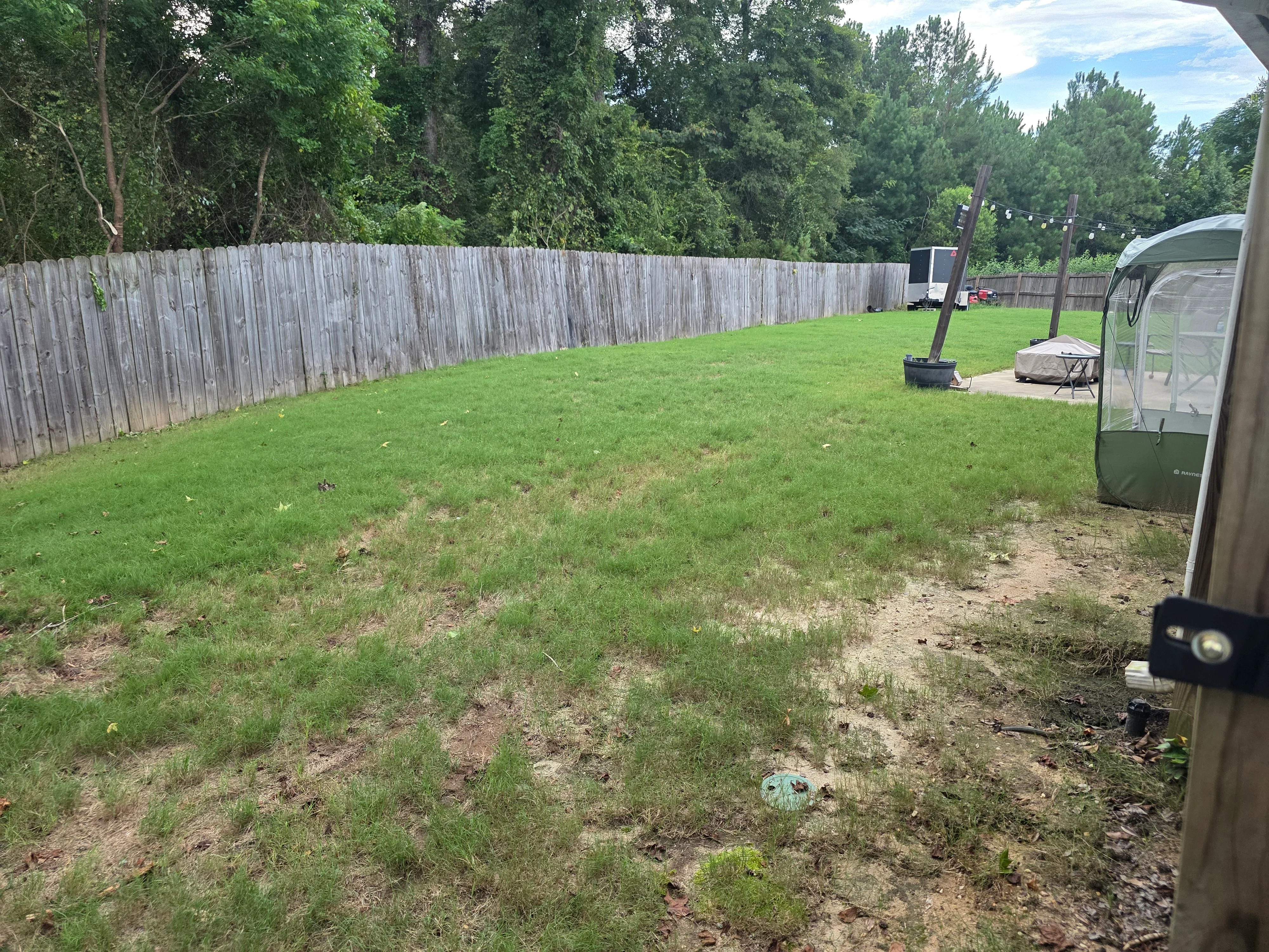 Cleared residential lot with bare earth, grass, and removed concrete debris