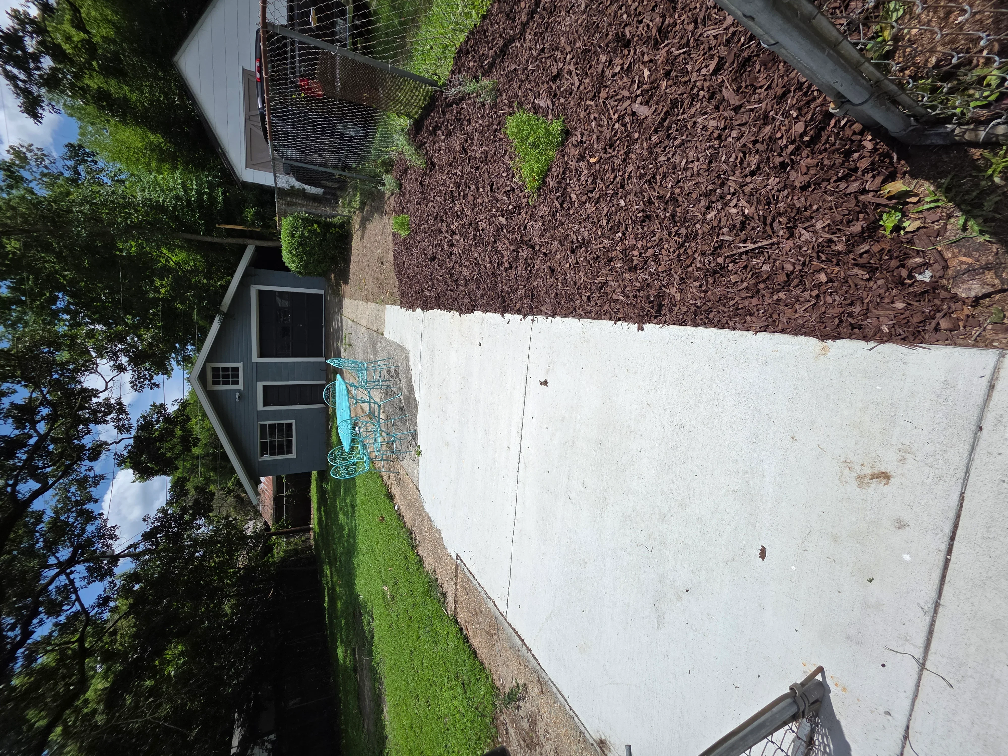 Removed concrete driveway area with mulch landscaping and residential property