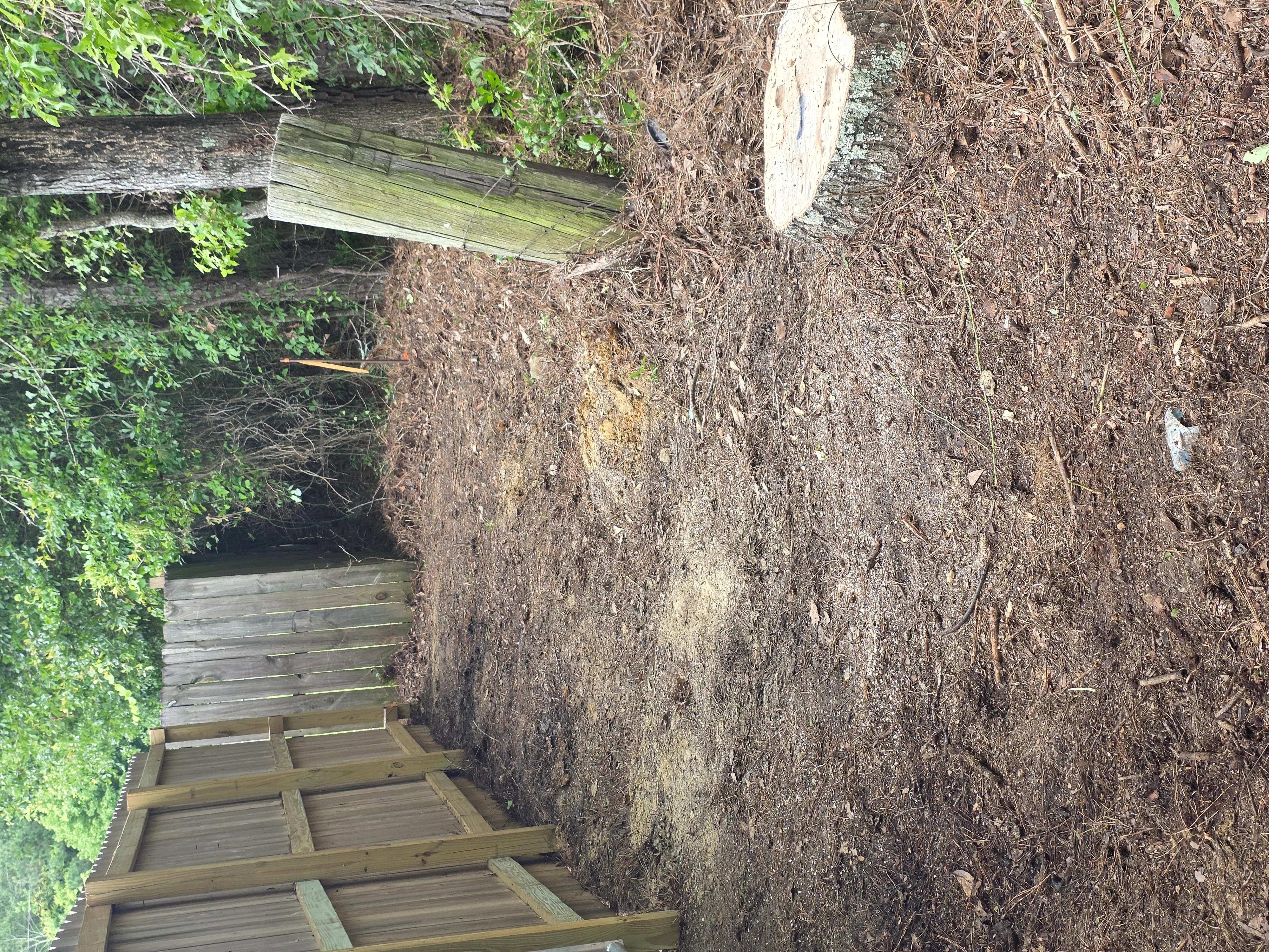 Cleared lot with removed brush, timber debris, and wooden frame foundation exposed