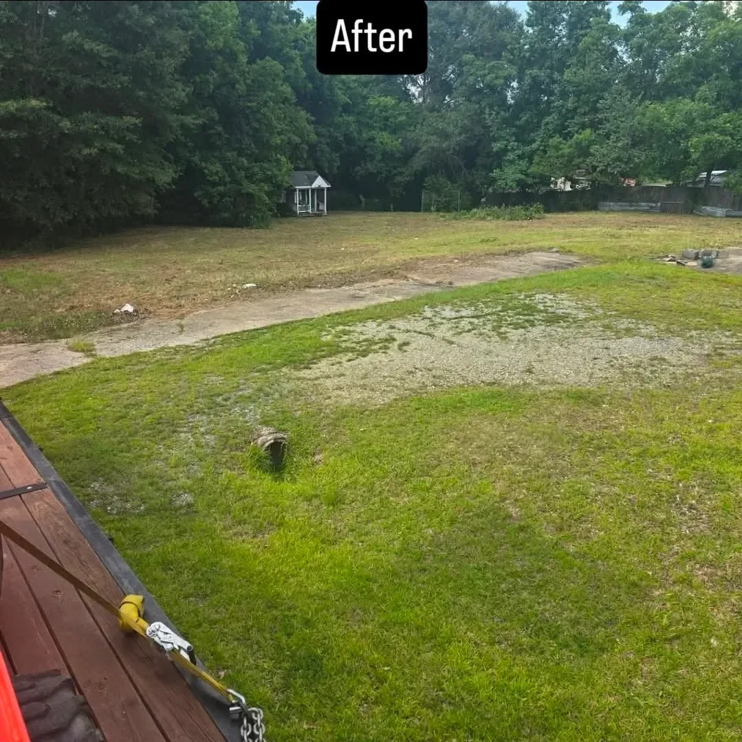 A residential property in Columbus, GA after a full cleanup, showing a cleared yard free of brush piles, scattered debris, and overgrown vegetation. The outdoor space is open, accessible, and ready for use.